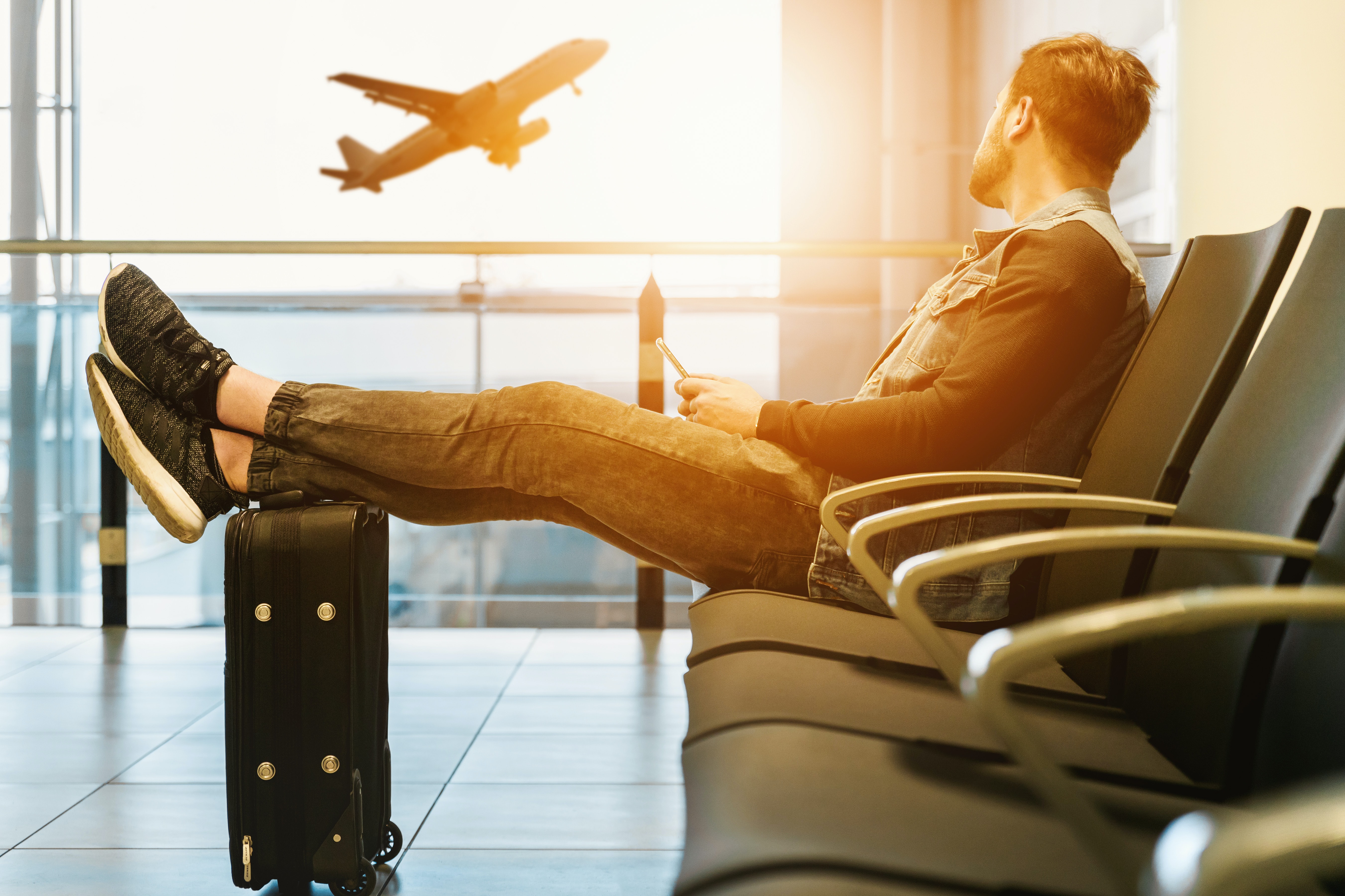 Man in airport watching aircraft take off